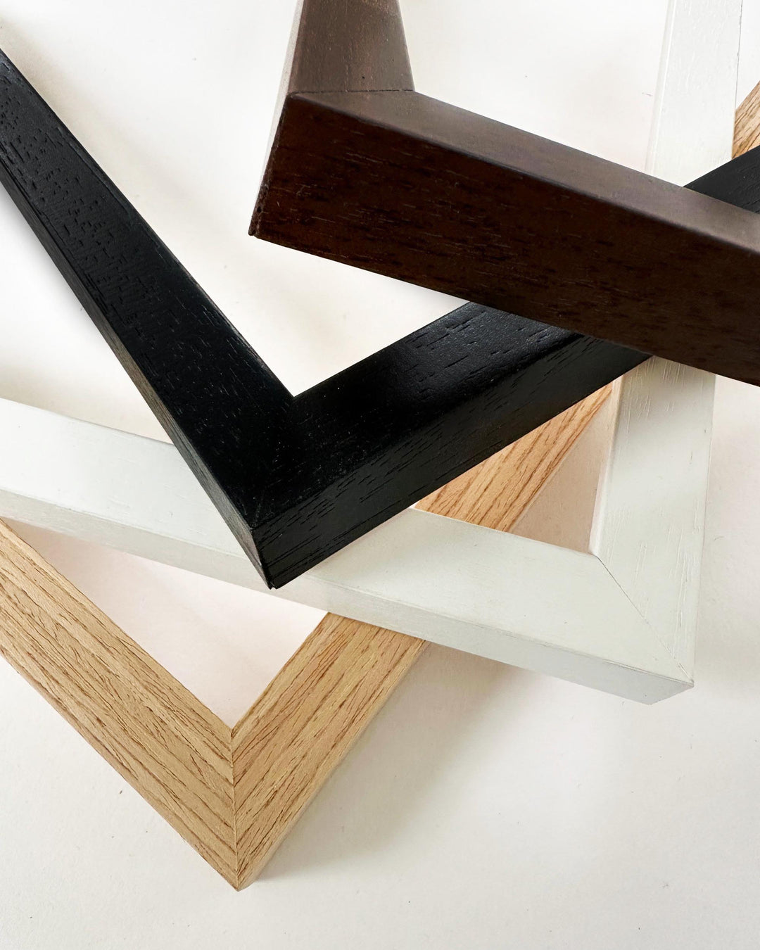Close-up of wooden picture frames with black and natural wood finishes on a white background.